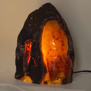 Agat lampe med naturlige mønstre og farvespil, der udsender et varmt og roligt lys i rummet.