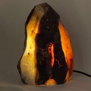 Agat lampe med naturlige mønstre og farvespil, der udsender et varmt og roligt lys i rummet.