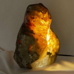 Agat lampe med naturlige mønstre og farvespil, der udsender et varmt og roligt lys i rummet.