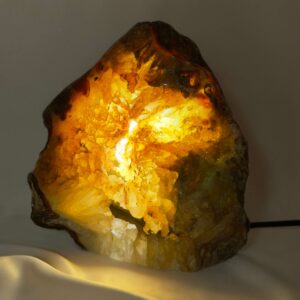 Agat lampe med naturlige mønstre og farvespil, der udsender et varmt og roligt lys i rummet.