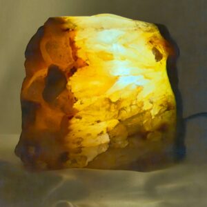 Agat lampe med naturlige mønstre og farvespil, der udsender et varmt og roligt lys i rummet.