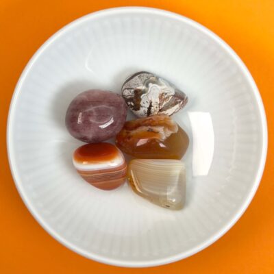 Healingssæt til harachakra med botswana agat, crazy lace agat, jordbærkvarts, karneol og sardonyx i varm og harmonisk opstilling