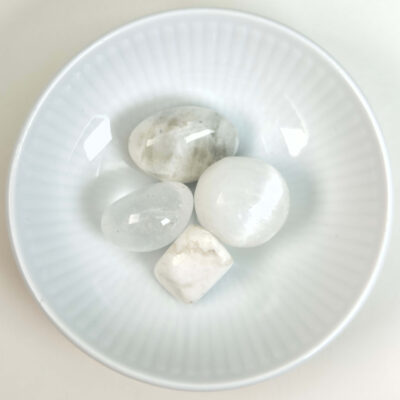 Healingssæt til kronechakra med bjergkrystal, howlit, lepidolit, regnbue månesten og selenit i rolig og spirituel opstilling