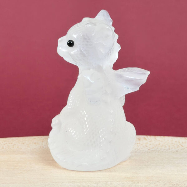 Sød Bjergkrystal babydrage, der symboliserer klarhed, positiv energi og spirituel fordybelse.