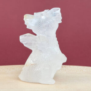 Sød Bjergkrystal babydrage, der symboliserer klarhed, positiv energi og spirituel fordybelse.