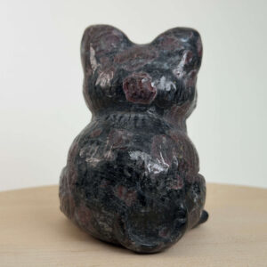 Granat kat med dybrøde nuancer, der symboliserer styrke, energi, grounding og personlig udvikling.