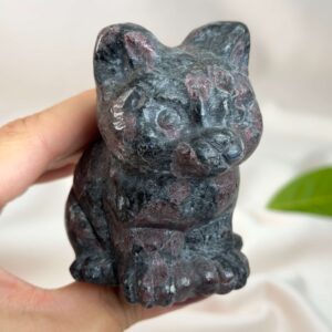 Granat kat med dybrøde nuancer, der symboliserer styrke, energi, grounding og personlig udvikling.
