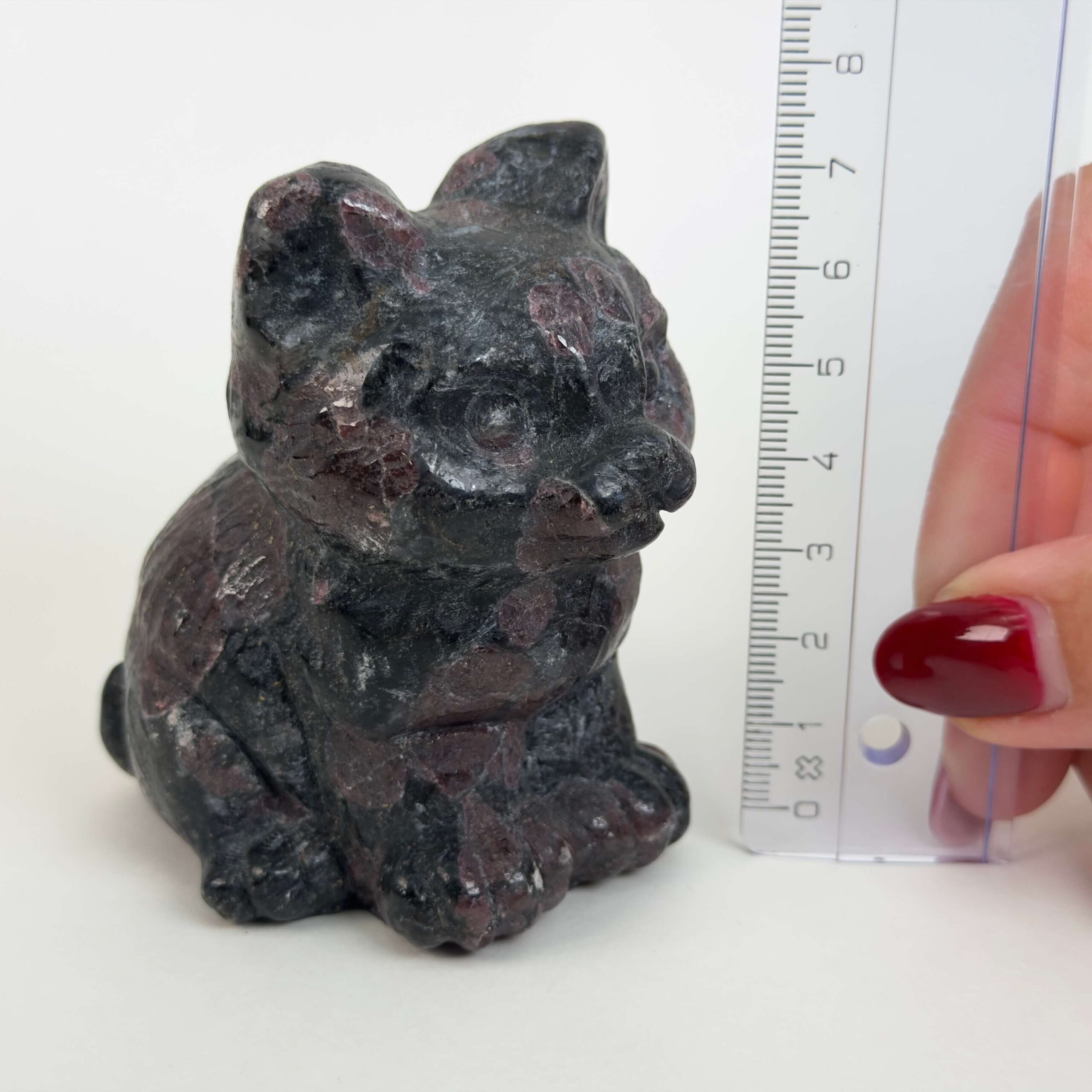 Granat kat med dybrøde nuancer, der symboliserer styrke, energi, grounding og personlig udvikling.