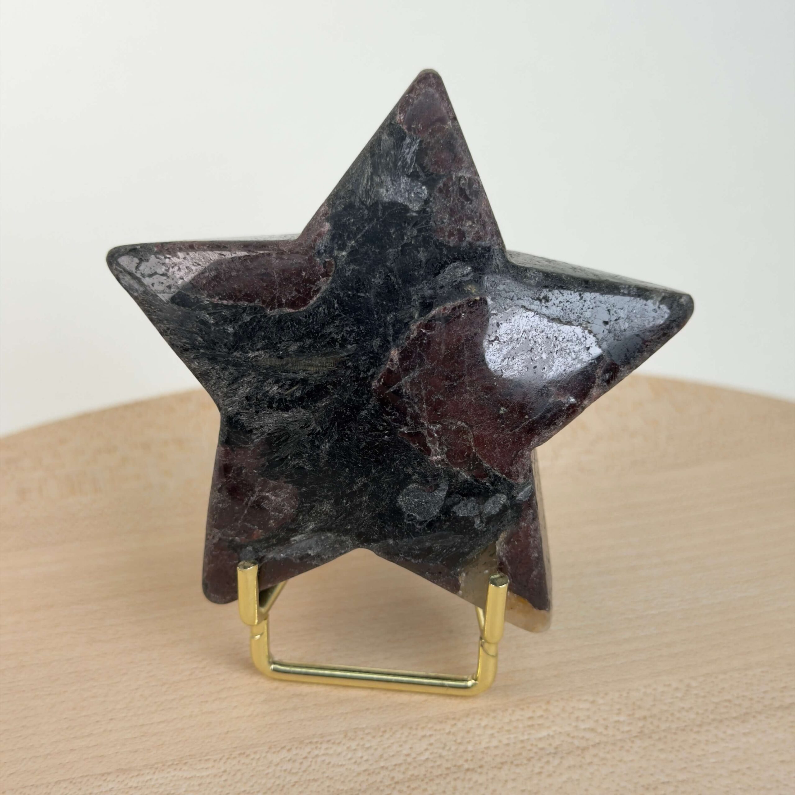 Granat stjerne med dybrøde nuancer og energi for styrke, motivation, grounding og personlig udvikling.