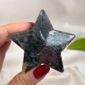 Granat stjerne med dybrøde nuancer og energi for styrke, motivation, grounding og personlig udvikling.