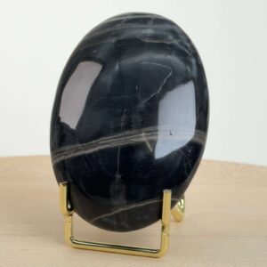 Sort Båndet Onyx Håndsten med glat, poleret overflade og naturlige sorte, grå og hvide bånd, der symboliserer grounding, beskyttelse og indre styrke.