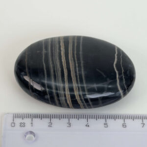 Sort Båndet Onyx Håndsten med glat, poleret overflade og naturlige sorte, grå og hvide bånd, der symboliserer grounding, beskyttelse og indre styrke.
