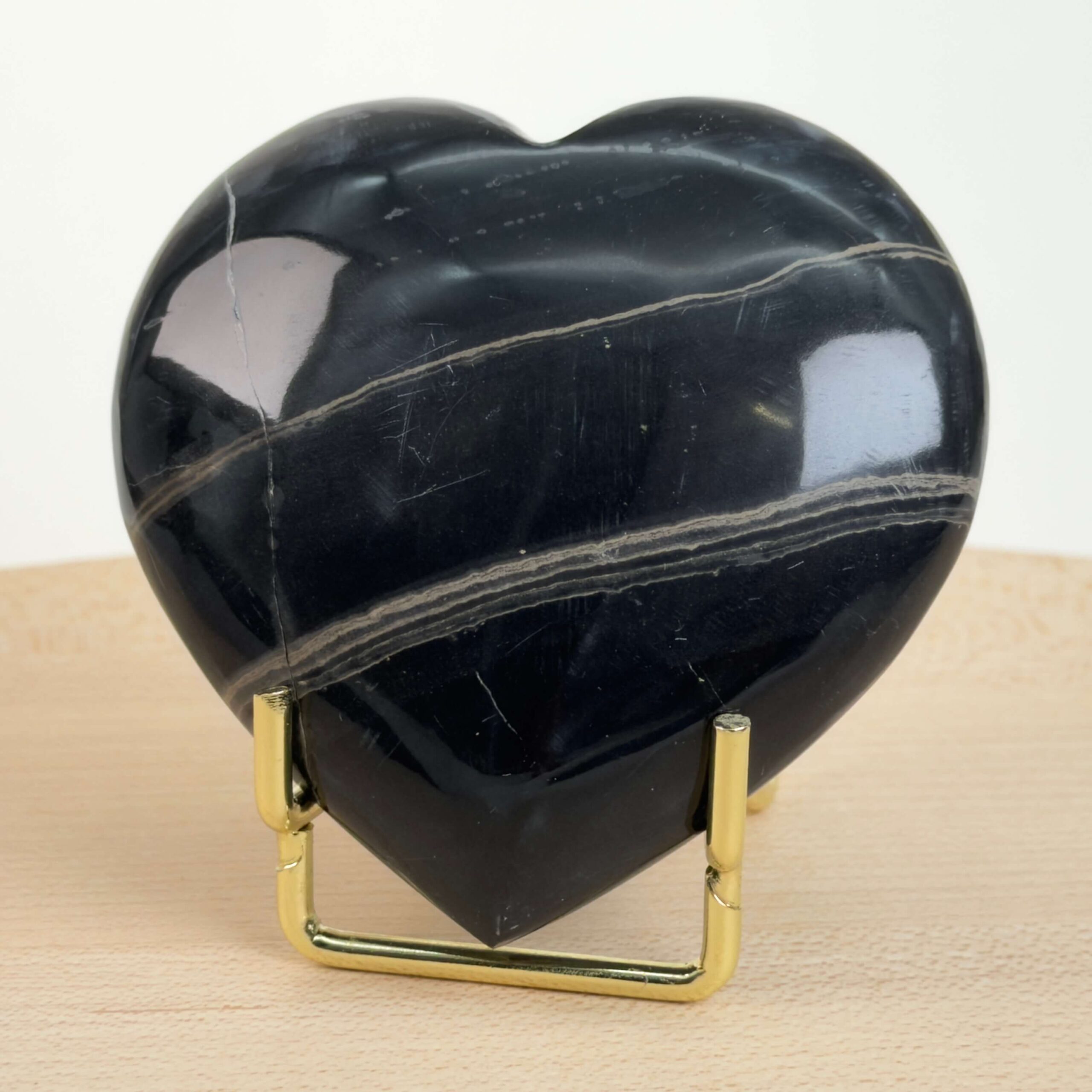 Sort Båndet Onyx hjerte med naturlige sorte, grå og hvide bånd, der symboliserer grounding, beskyttelse og indre styrke.
