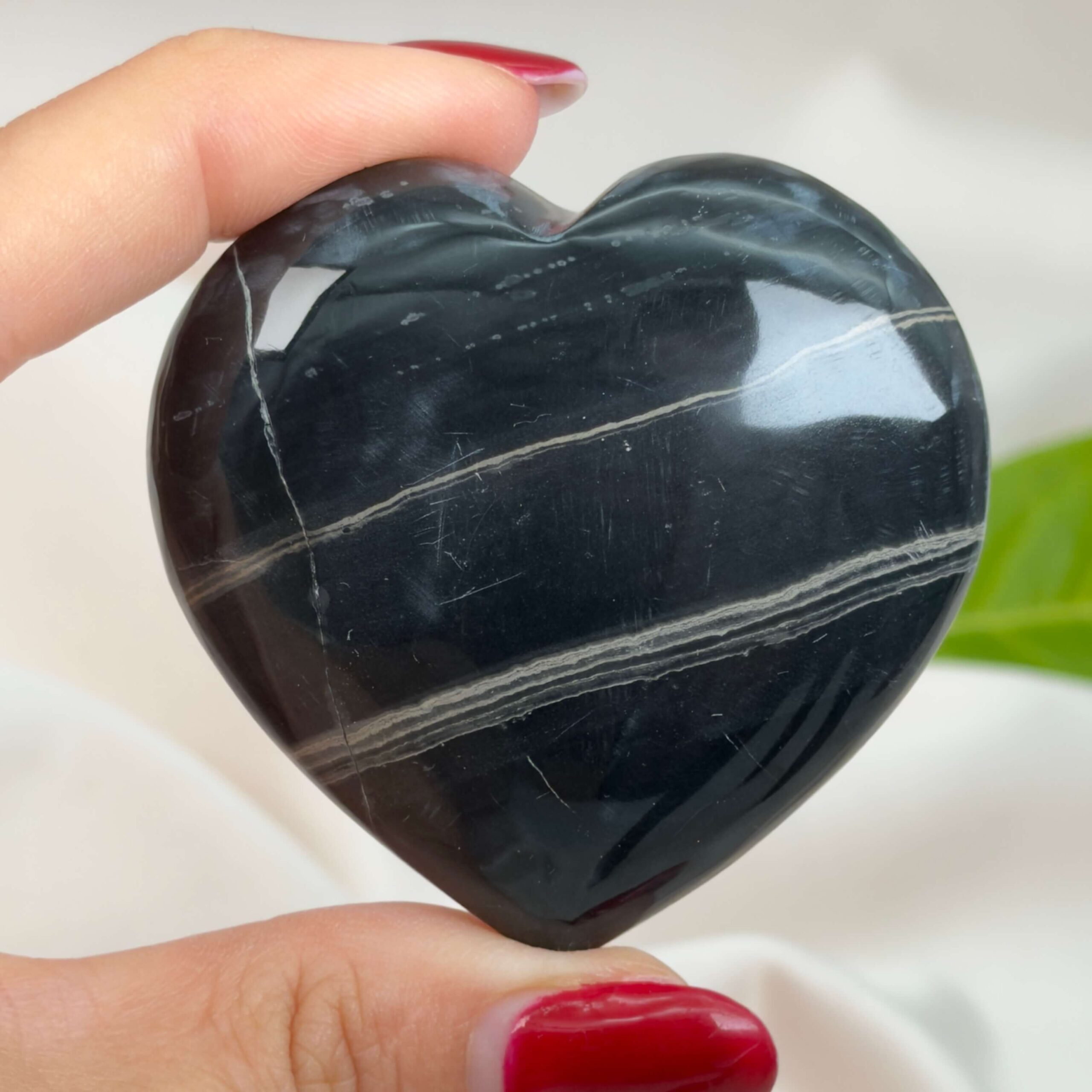 Sort Båndet Onyx hjerte med naturlige sorte, grå og hvide bånd, der symboliserer grounding, beskyttelse og indre styrke.