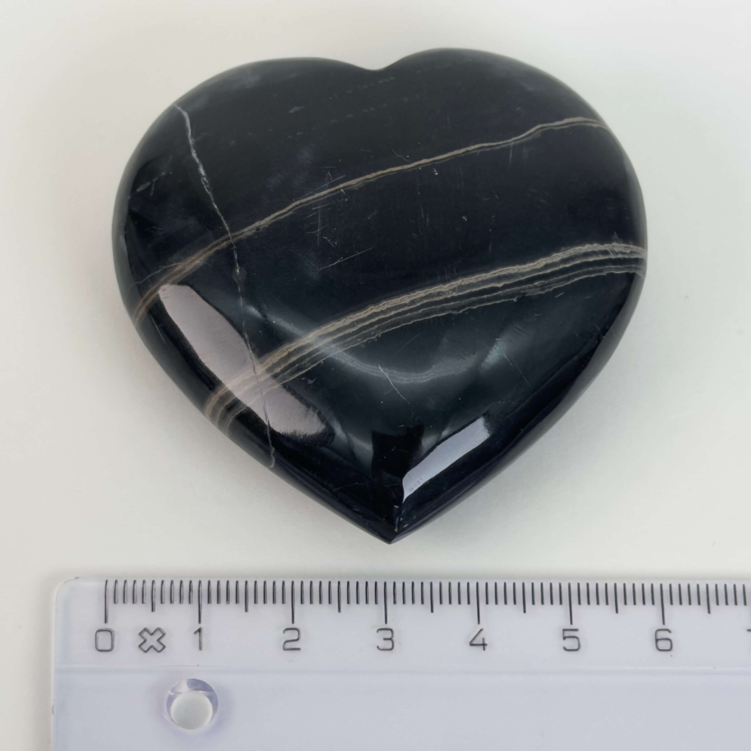 Sort Båndet Onyx hjerte med naturlige sorte, grå og hvide bånd, der symboliserer grounding, beskyttelse og indre styrke.