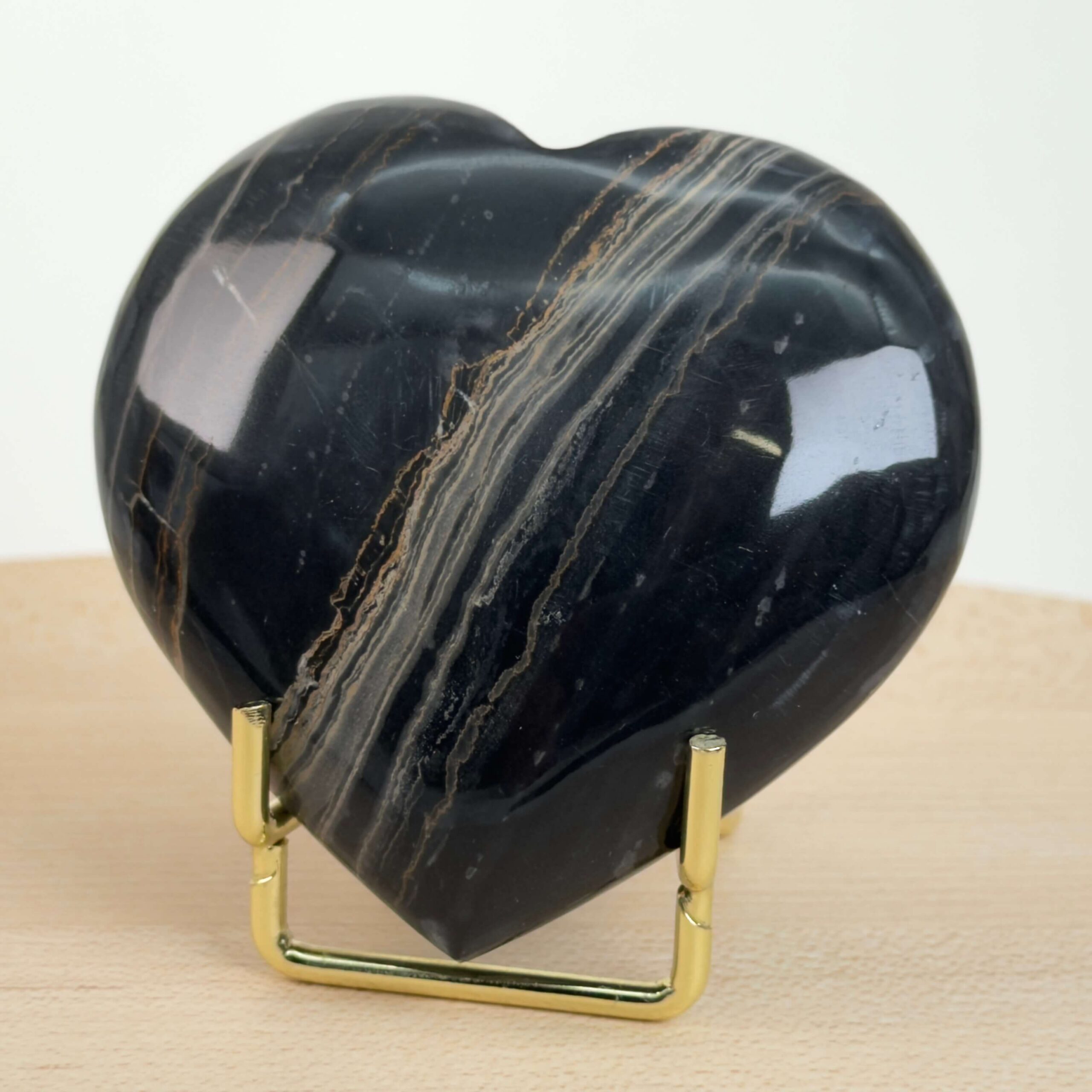 Sort Båndet Onyx hjerte med naturlige sorte, grå og hvide bånd, der symboliserer grounding, beskyttelse og indre styrke.