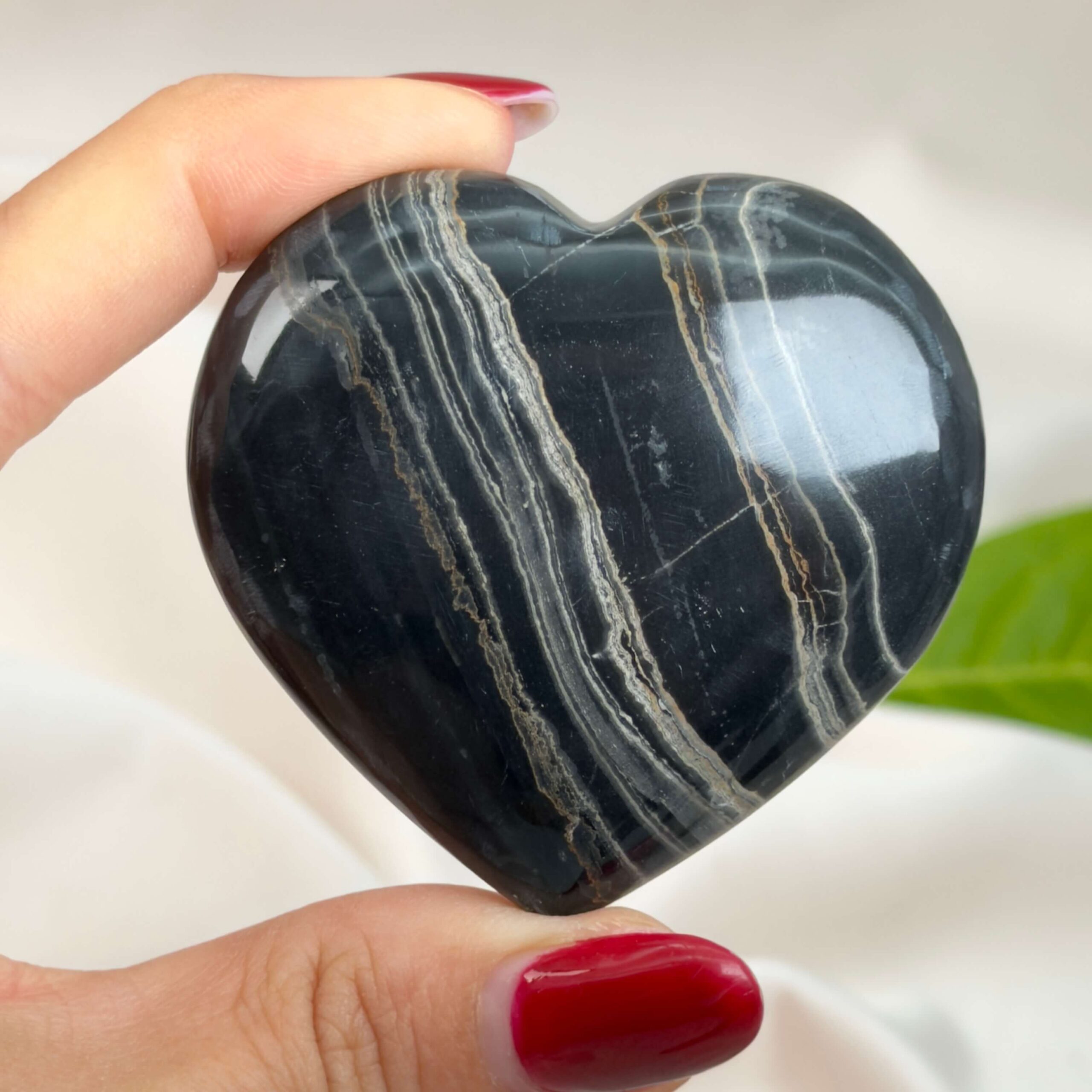 Sort Båndet Onyx hjerte med naturlige sorte, grå og hvide bånd, der symboliserer grounding, beskyttelse og indre styrke.