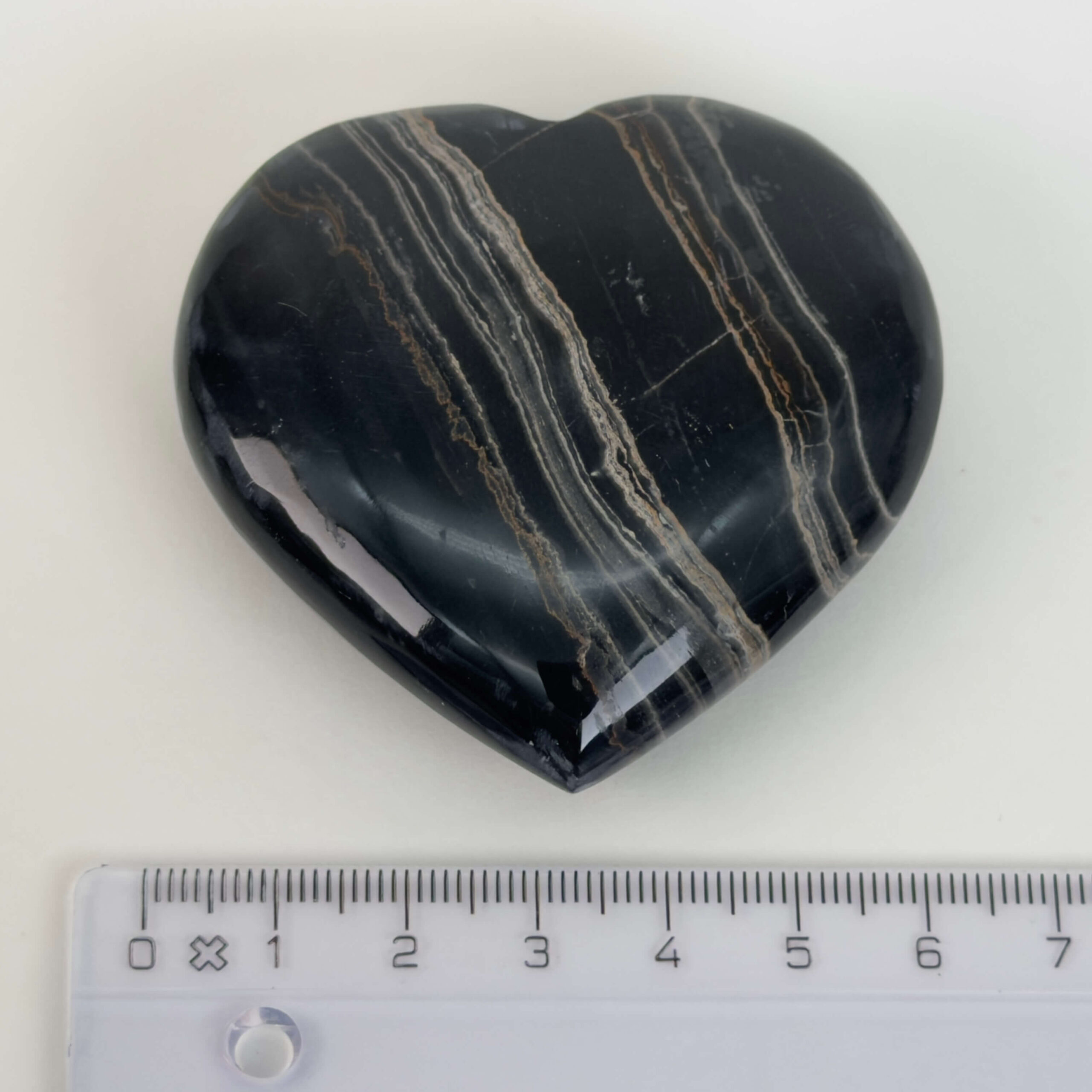 Sort Båndet Onyx hjerte med naturlige sorte, grå og hvide bånd, der symboliserer grounding, beskyttelse og indre styrke.