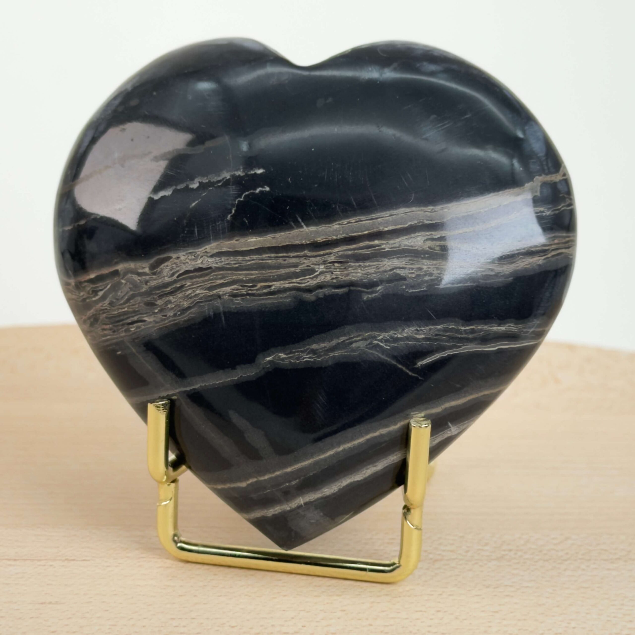 Sort Båndet Onyx hjerte med naturlige sorte, grå og hvide bånd, der symboliserer grounding, beskyttelse og indre styrke.
