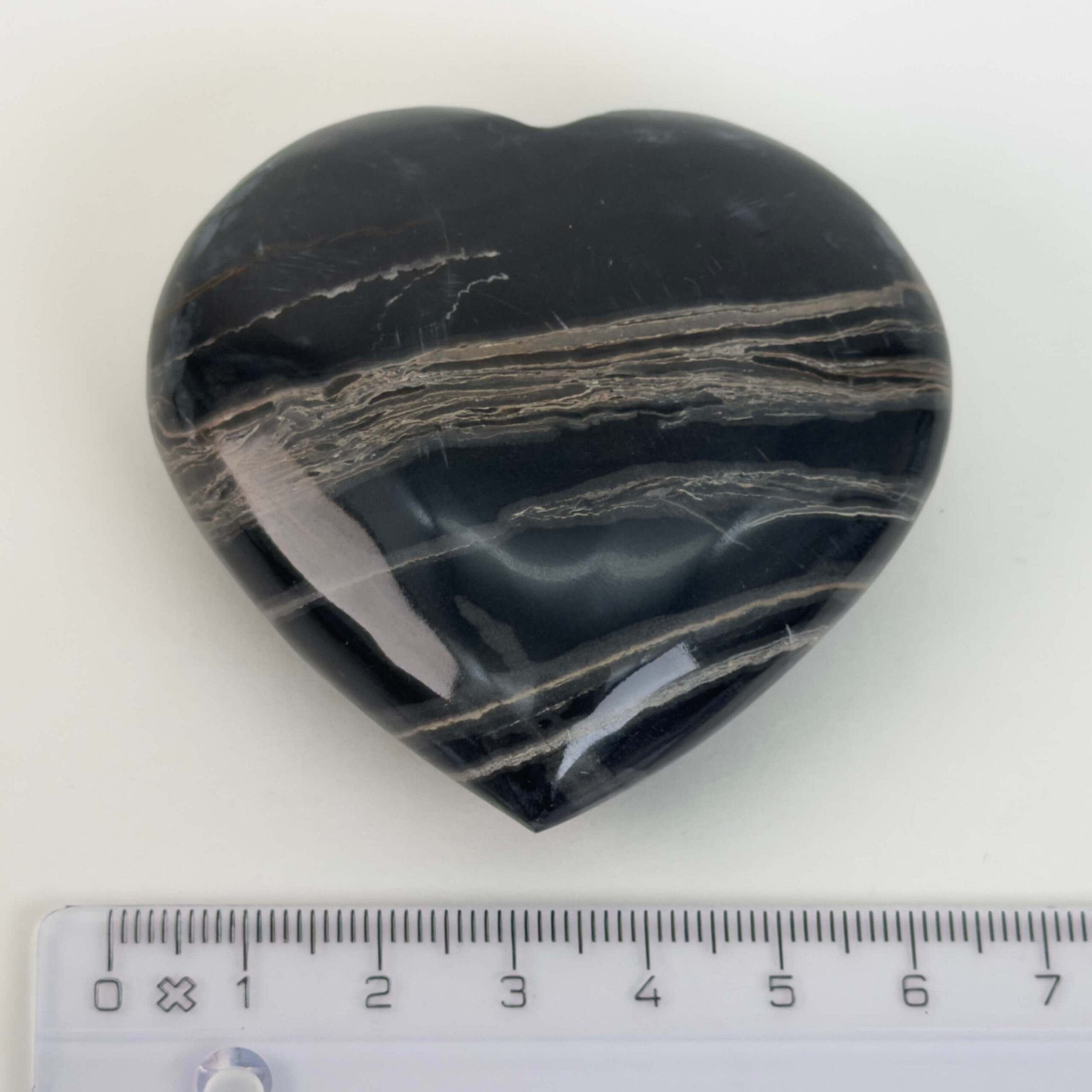 Sort Båndet Onyx hjerte med naturlige sorte, grå og hvide bånd, der symboliserer grounding, beskyttelse og indre styrke.