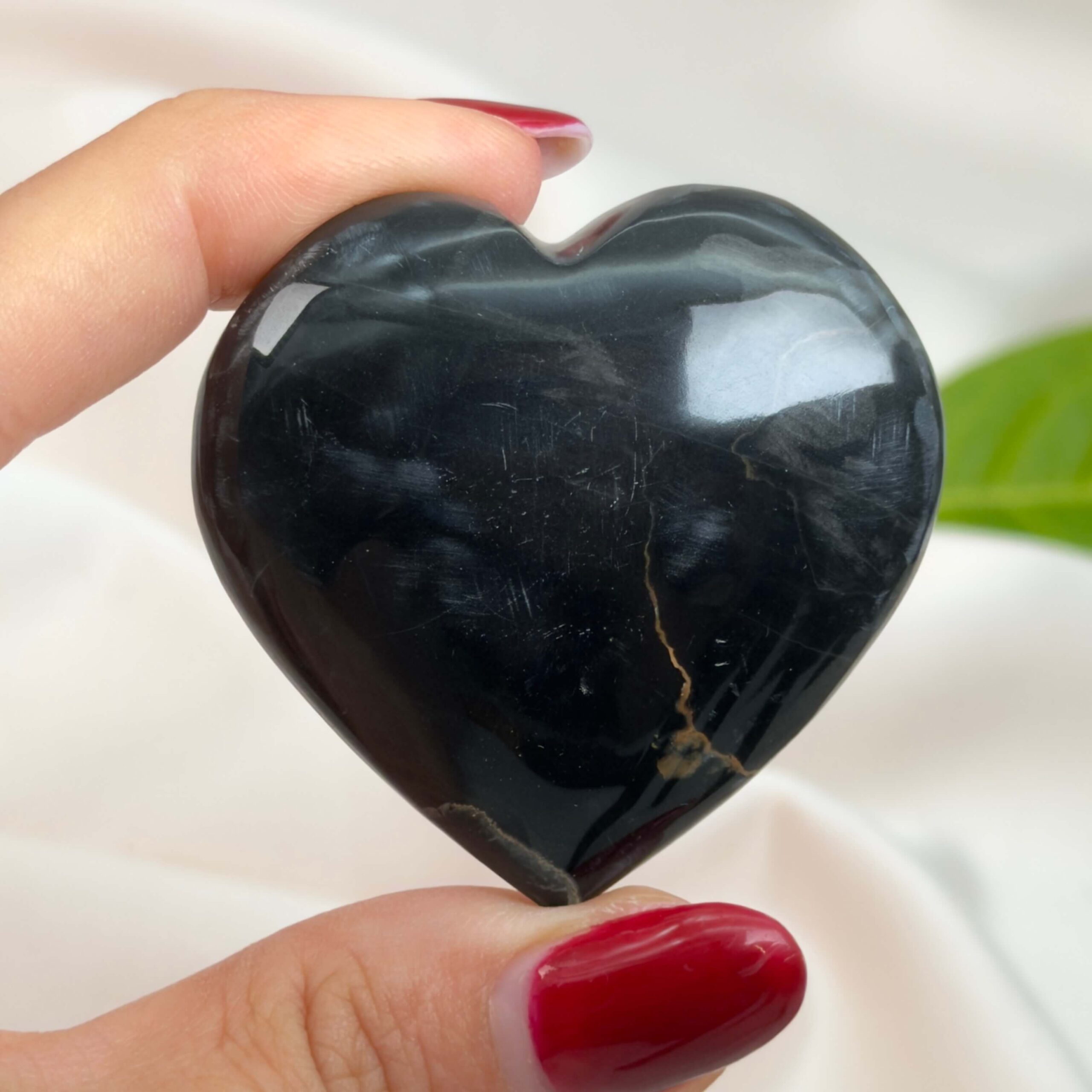 Sort Båndet Onyx hjerte med naturlige sorte, grå og hvide bånd, der symboliserer grounding, beskyttelse og indre styrke.