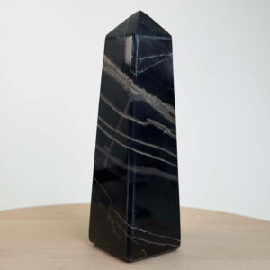 Sort Båndet Onyx tårn med naturlige sorte, grå og hvide bånd, der symboliserer grounding, beskyttelse og indre styrke.