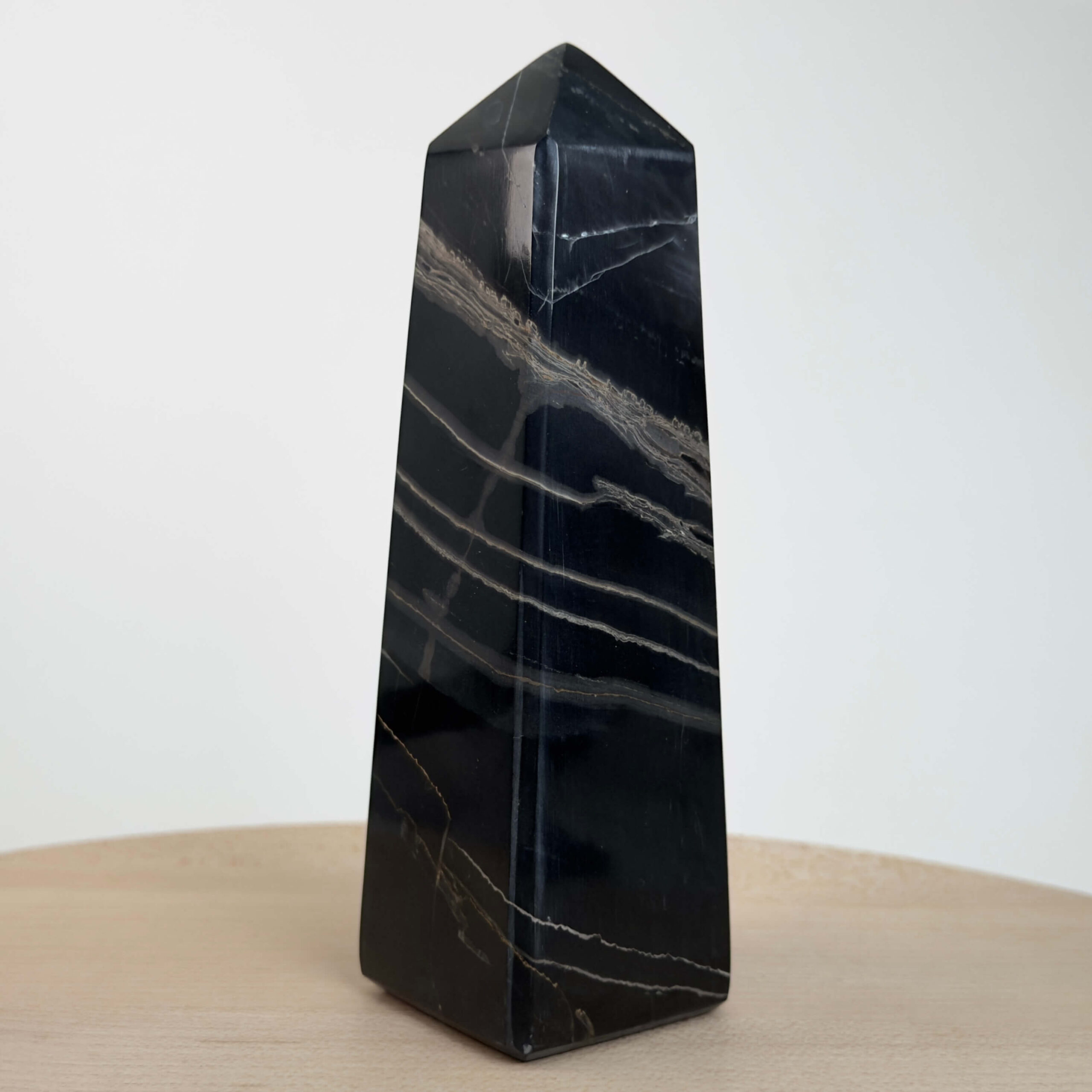 Sort Båndet Onyx tårn med naturlige sorte, grå og hvide bånd, der symboliserer grounding, beskyttelse og indre styrke.