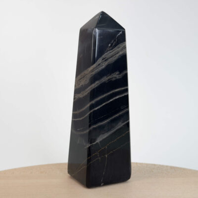 Sort Båndet Onyx tårn med naturlige sorte, grå og hvide bånd, der symboliserer grounding, beskyttelse og indre styrke.