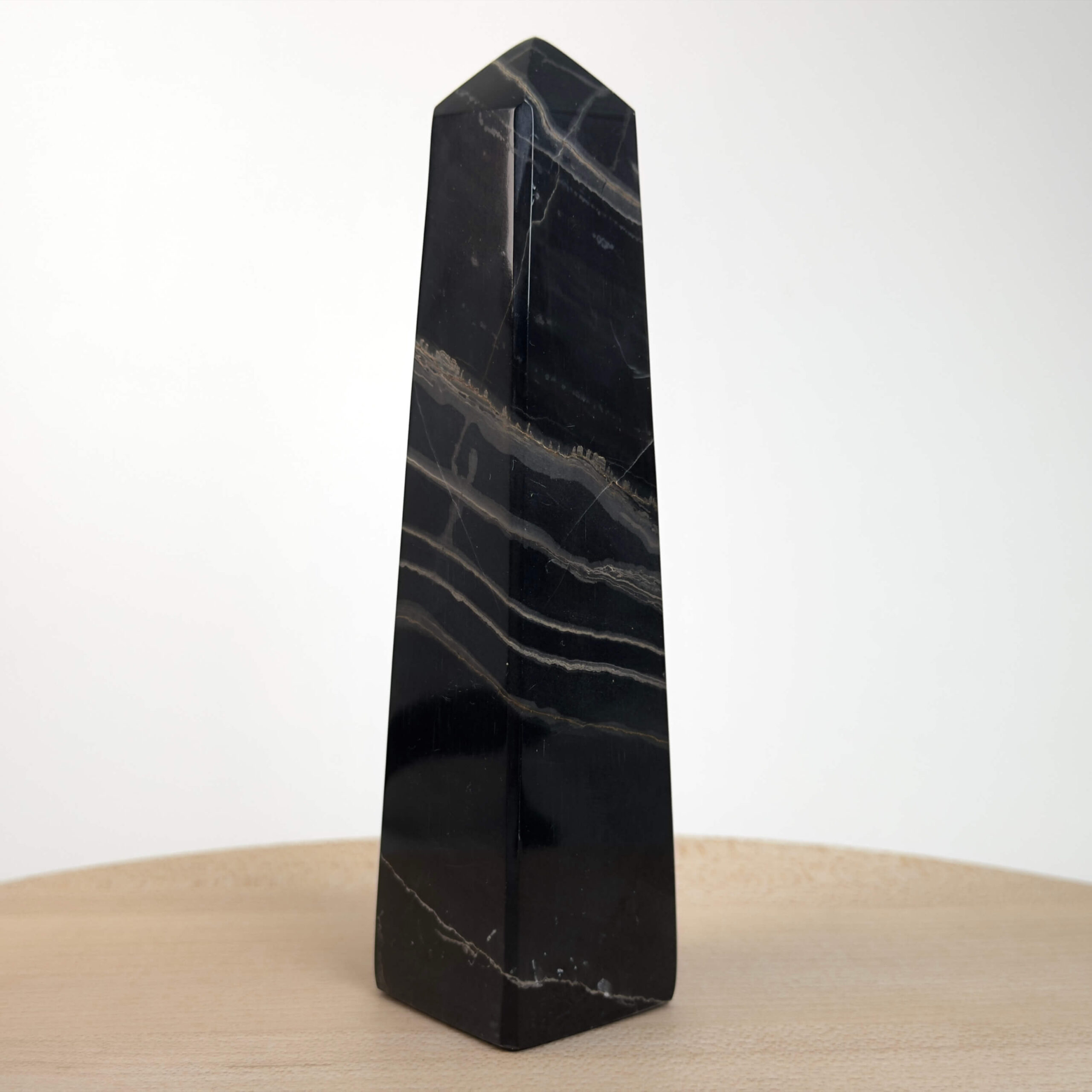 Sort Båndet Onyx tårn med naturlige sorte, grå og hvide bånd, der symboliserer grounding, beskyttelse og indre styrke.