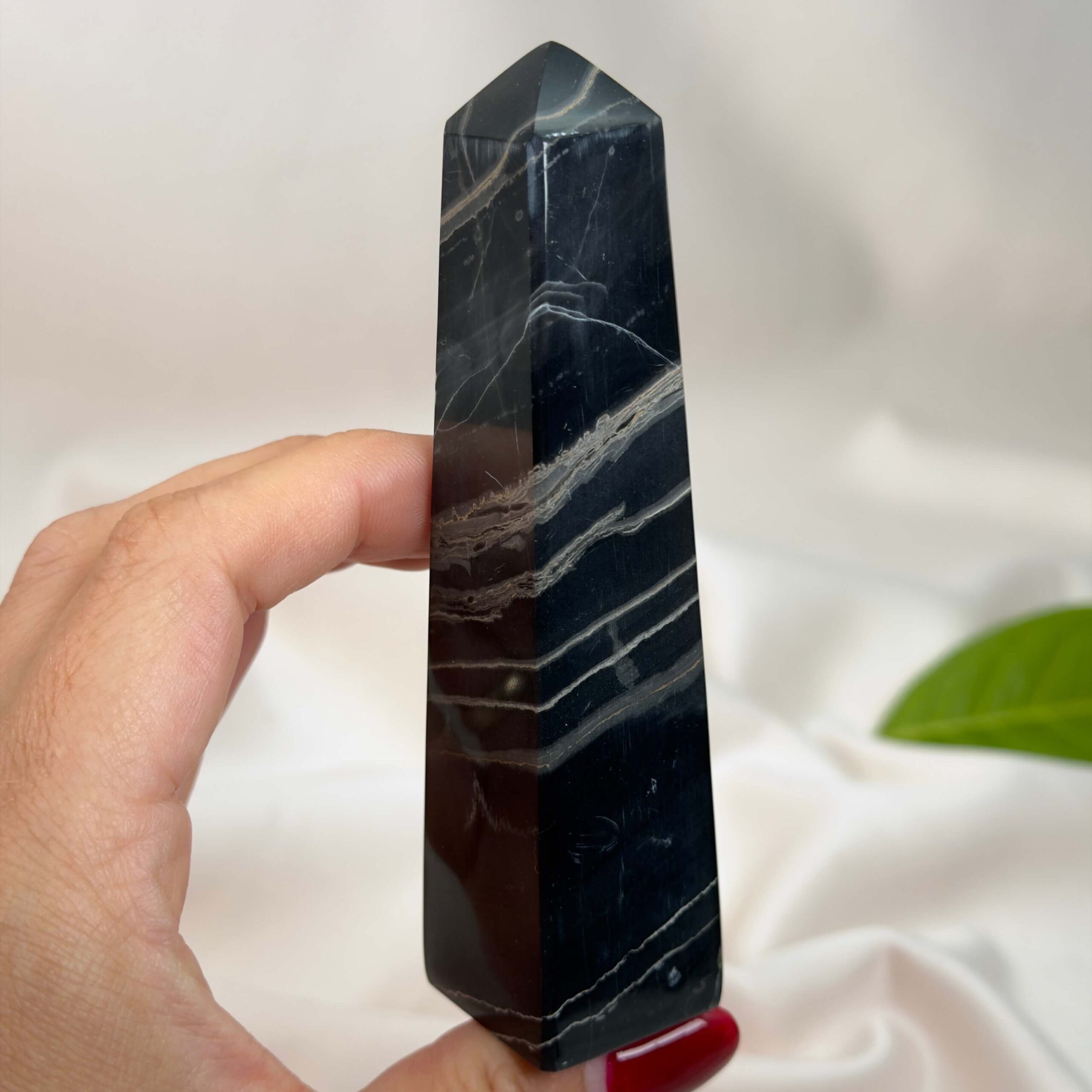 Sort Båndet Onyx tårn med naturlige sorte, grå og hvide bånd, der symboliserer grounding, beskyttelse og indre styrke.