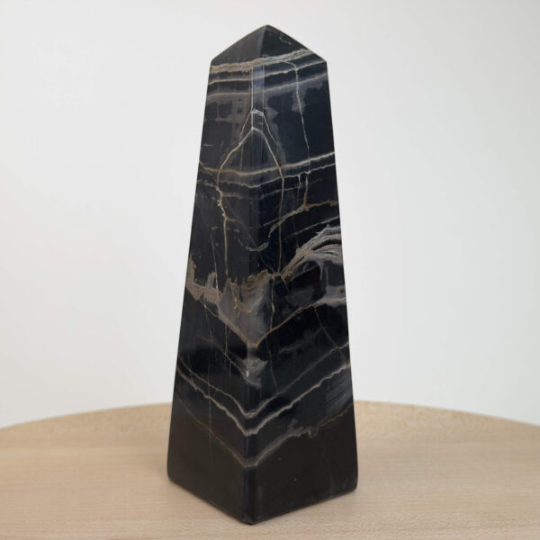 Sort Båndet Onyx tårn med naturlige sorte, grå og hvide bånd, der symboliserer grounding, beskyttelse og indre styrke.