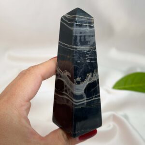 Sort Båndet Onyx tårn med naturlige sorte, grå og hvide bånd, der symboliserer grounding, beskyttelse og indre styrke.