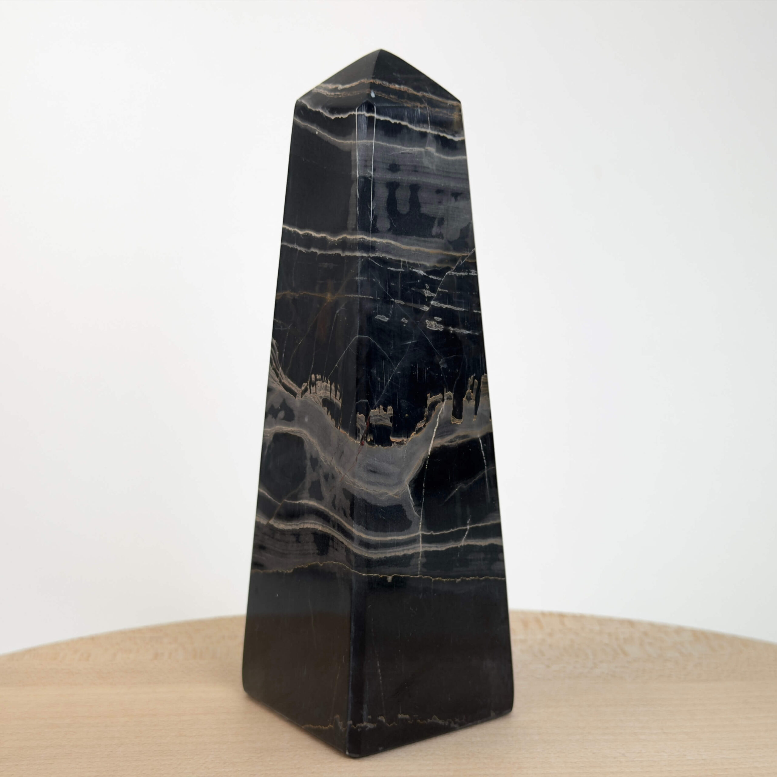 Sort Båndet Onyx tårn med naturlige sorte, grå og hvide bånd, der symboliserer grounding, beskyttelse og indre styrke.