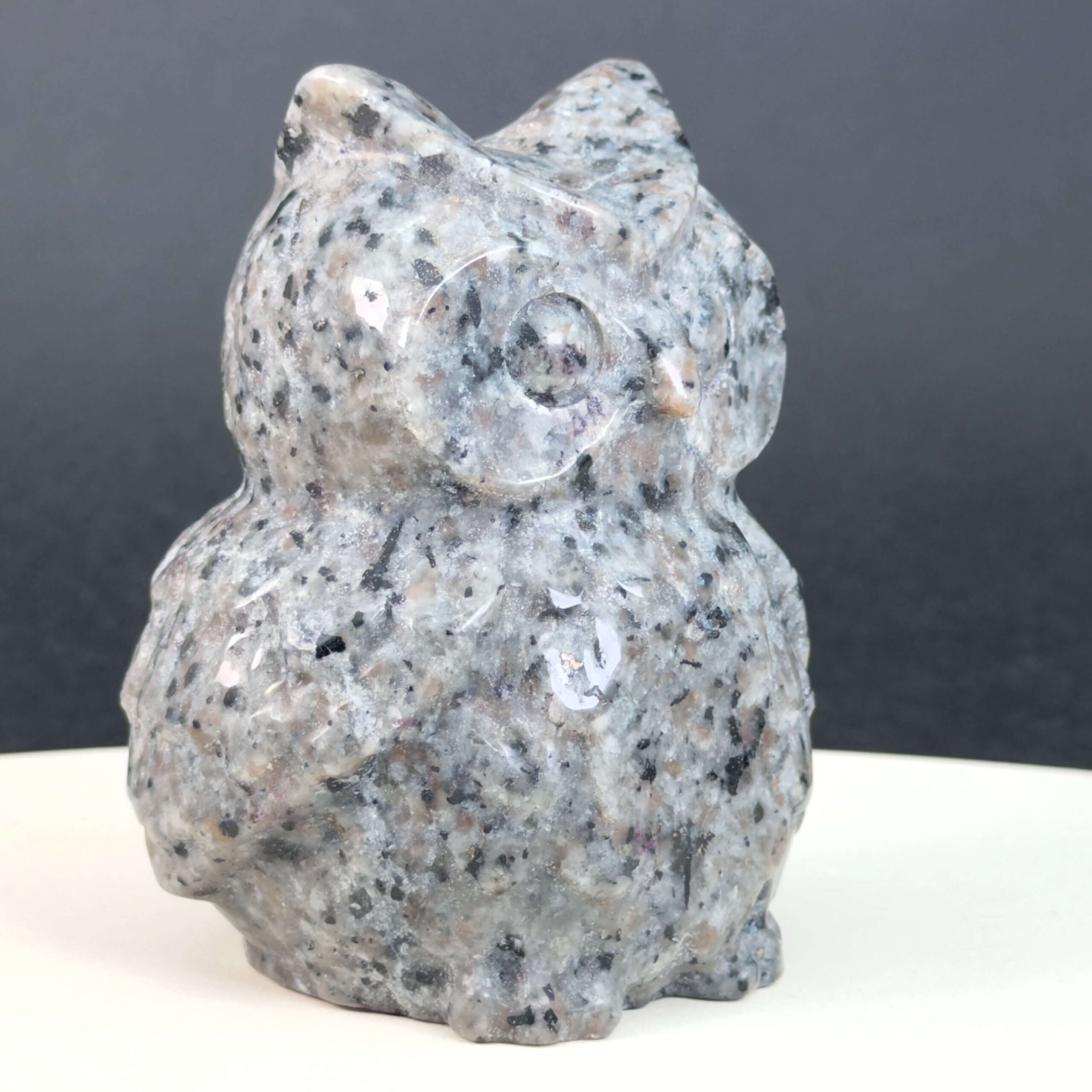 Yooperlite Ugle med naturlige grå nuancer og orange fluorescens under UV-lys samt symbolik for visdom, intuition, klarhed og selvudtryk.