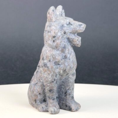 Yooperlite Ulvehund med naturlige grå nuancer og orange fluorescens under UV-lys samt symbolik for loyalitet, intuition og indre styrke.