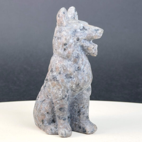 Yooperlite Ulvehund med naturlige grå nuancer og orange fluorescens under UV-lys samt symbolik for loyalitet, intuition og indre styrke.