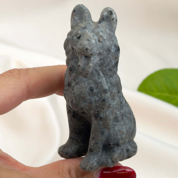 Yooperlite Ulvehund med naturlige grå nuancer og orange fluorescens under UV-lys samt symbolik for loyalitet, intuition og indre styrke.