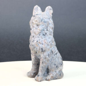 Yooperlite Ulvehund med naturlige grå nuancer og orange fluorescens under UV-lys samt symbolik for loyalitet, intuition og indre styrke.