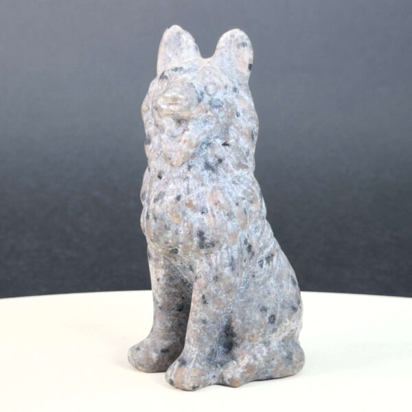 Yooperlite Ulvehund med naturlige grå nuancer og orange fluorescens under UV-lys samt symbolik for loyalitet, intuition og indre styrke.