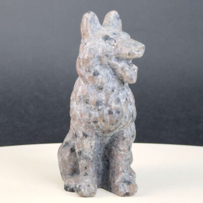 Yooperlite Ulvehund med naturlige grå nuancer og orange fluorescens under UV-lys samt symbolik for loyalitet, intuition og indre styrke.