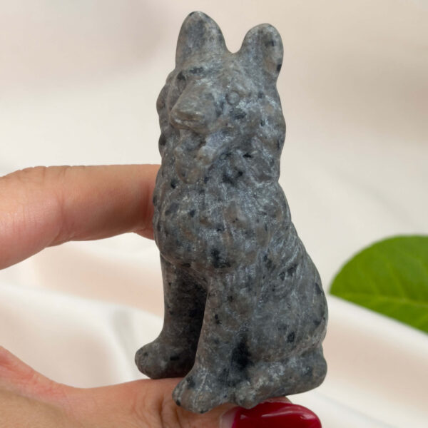 Yooperlite Ulvehund med naturlige grå nuancer og orange fluorescens under UV-lys samt symbolik for loyalitet, intuition og indre styrke.