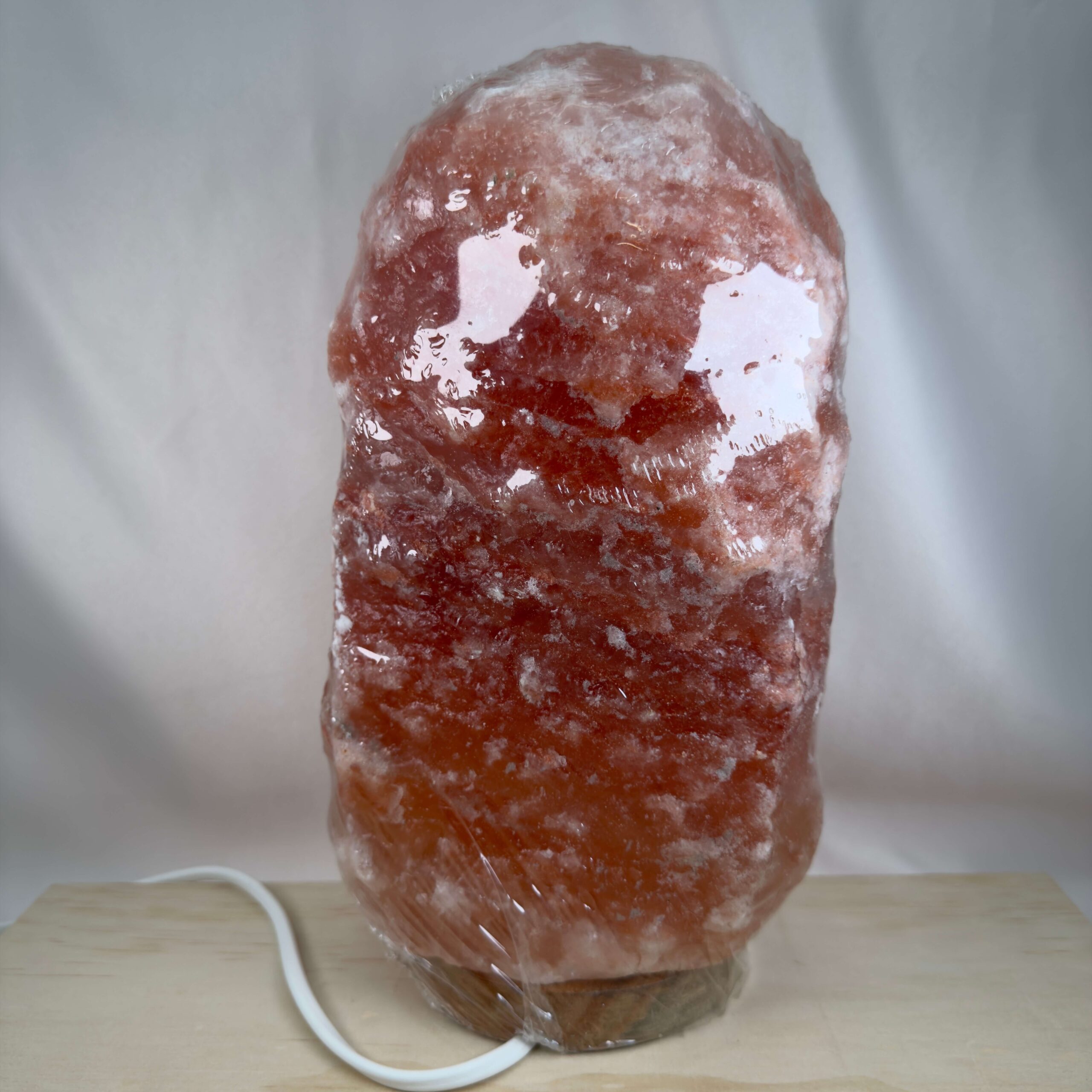 Himalaya Saltlampe Nr. 2 tændt med varmt lys gennem naturligt rosa og orange stensalt