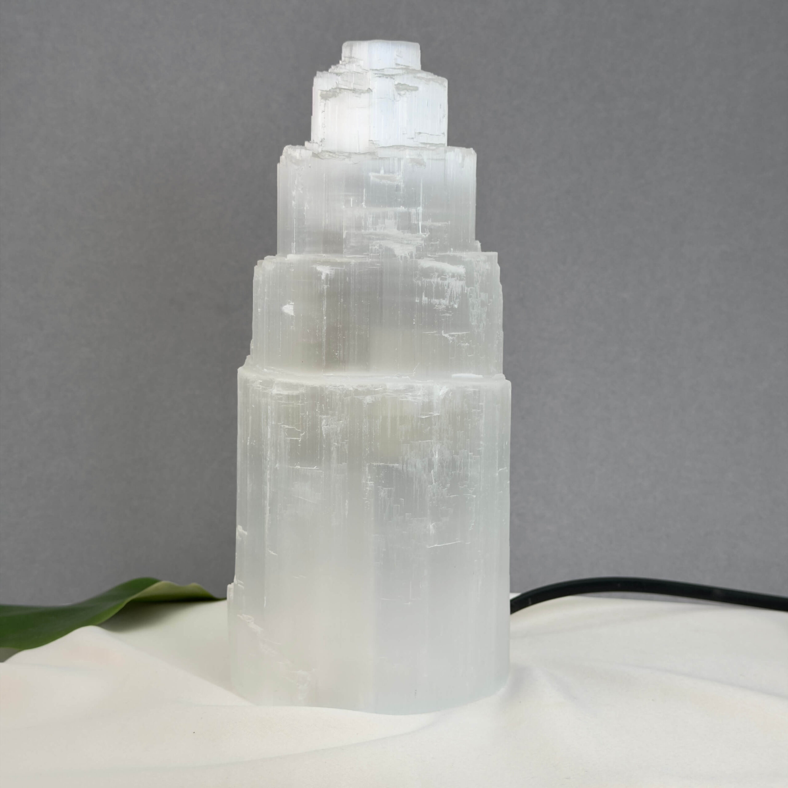 Unik Selenit lampe formet som tårn med naturlige lyse lag og struktur